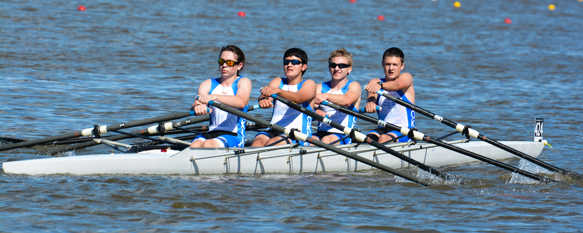 Image of four Junior Crew members rowing on the Oklahoma River