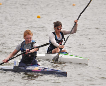 Image of Two female sprint kayakers racing on the Oklahoma River